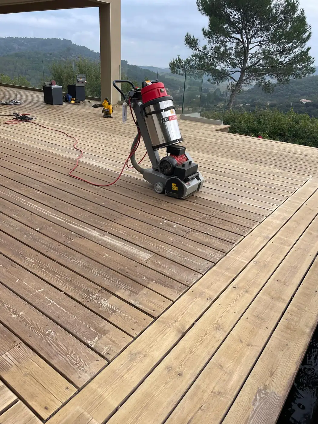 Monobrosse sur une grande terrasse en bois, pendant le brossage